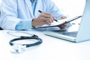 doctor completing insurance forms
